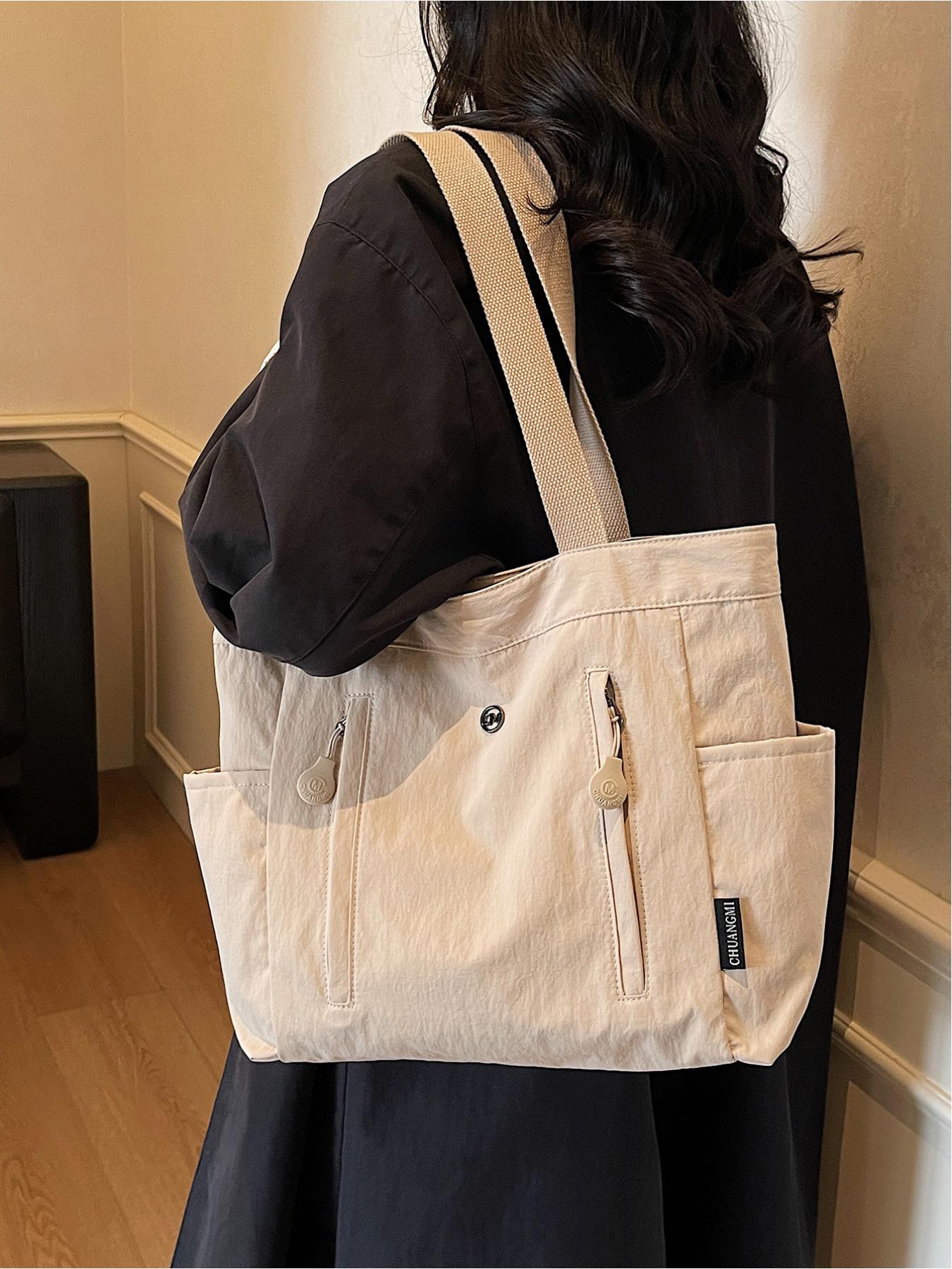 The large capacity soft commuter tote bag, is lightweight, spacious, suitable for daily use. It is a neutral waterproof nylon shoulder bag with a spacious interior suitable for 15 inch laptops, multiple side pockets, and a comfortable adjustab