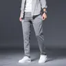 Men's slim-fit dress trousers made of polyester, spandex, and viscose fabric, available in multiple colors (sizes: 28-38).