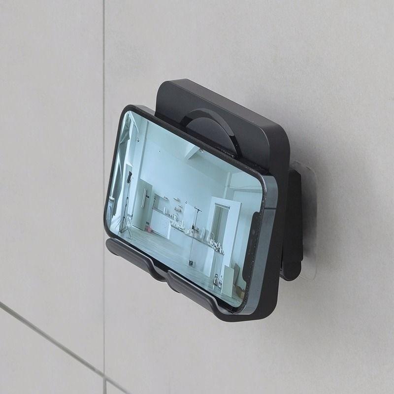 A wall-mounted phone holder, Electronic Mobile Accessory, Cell Phone Holders, featuring punch-free installation and adjustable angle, is a practical gift suitable for installation on walls in bedrooms, living rooms, kitchens, bathrooms, etc