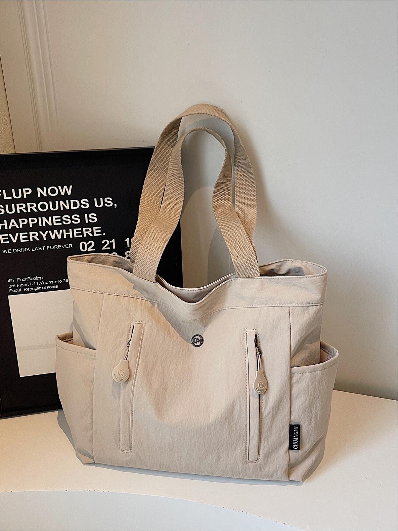 The large capacity soft commuter tote bag, is lightweight, spacious, suitable for daily use. It is a neutral waterproof nylon shoulder bag with a spacious interior suitable for 15 inch laptops, multiple side pockets, and a comfortable adjustab