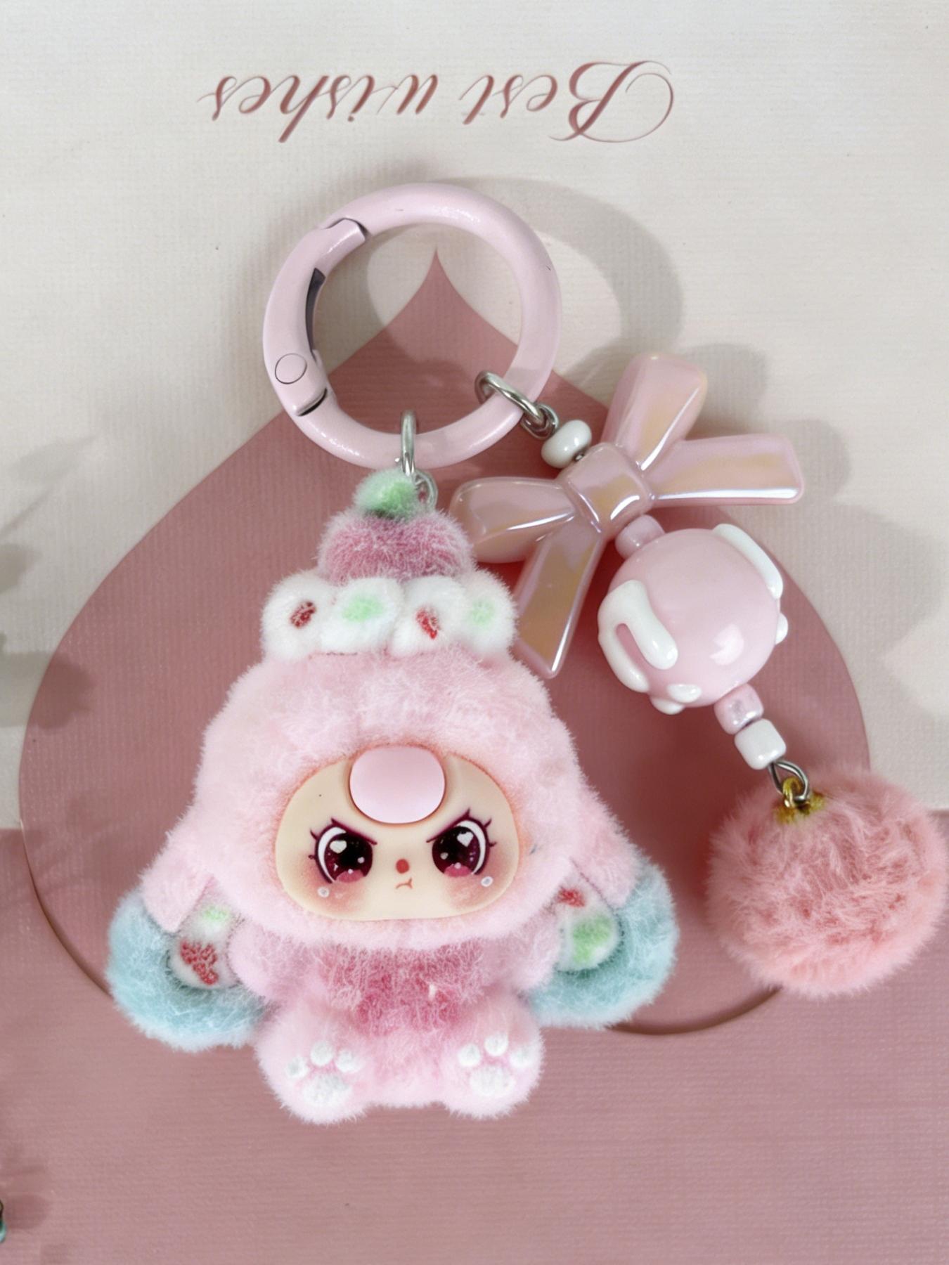 A cute pendant featuring a multi-colored plush doll, paired with a bow ...