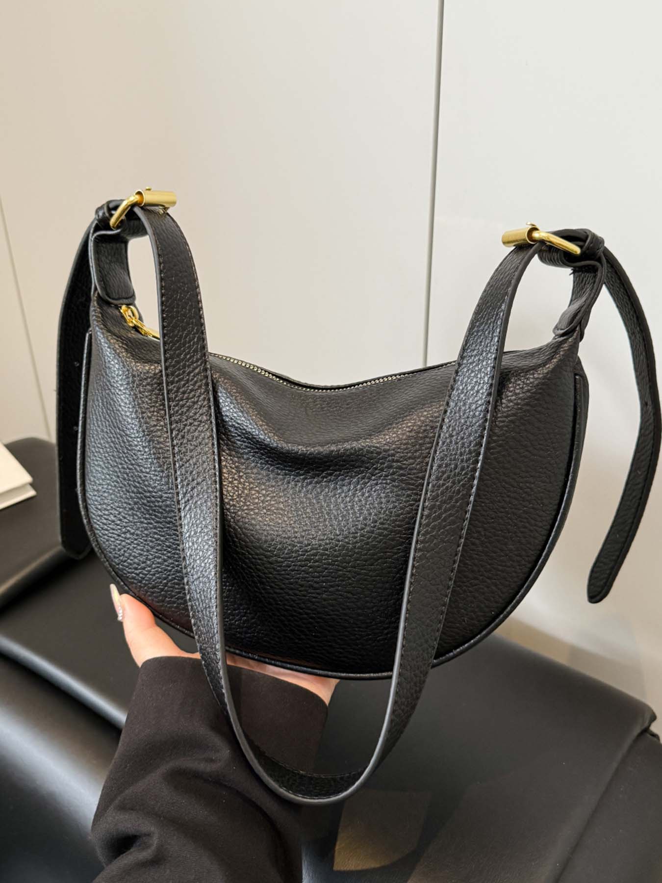 Black simple and fashionable lychee pattern crescent bag, niche pleated bag body, adjustable wide shoulder strap crossbody bag, metal buckle decoration, lightweight daily commuter bag, suitable for shopping, dating, etc.