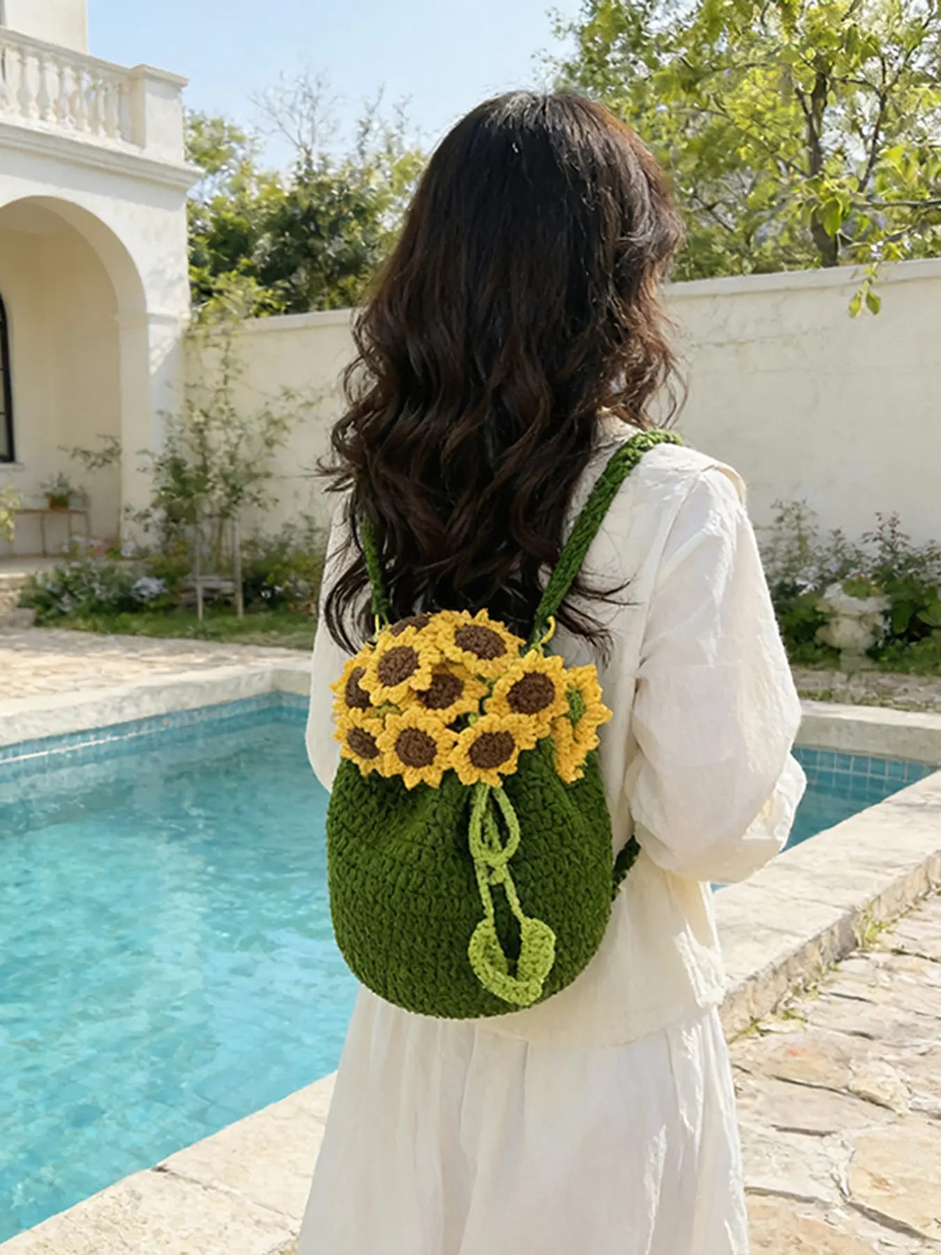 A niche handmade crochet backpack, featuring green sunflower flower accessories and a drawstring design, with adjustable shoulder straps. A stylish and versatile backpack perfect for daily commuting, shopping, and outings.