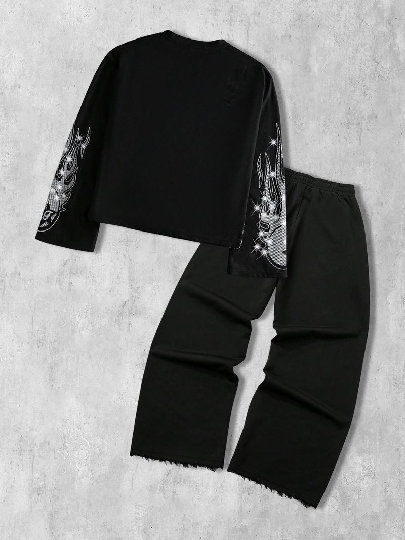 This men's two-piece set features a gothic streetwear design, including a long-sleeved T-shirt with a shimmering flame print and black flared trousers adorned with rhinestones and lettering.