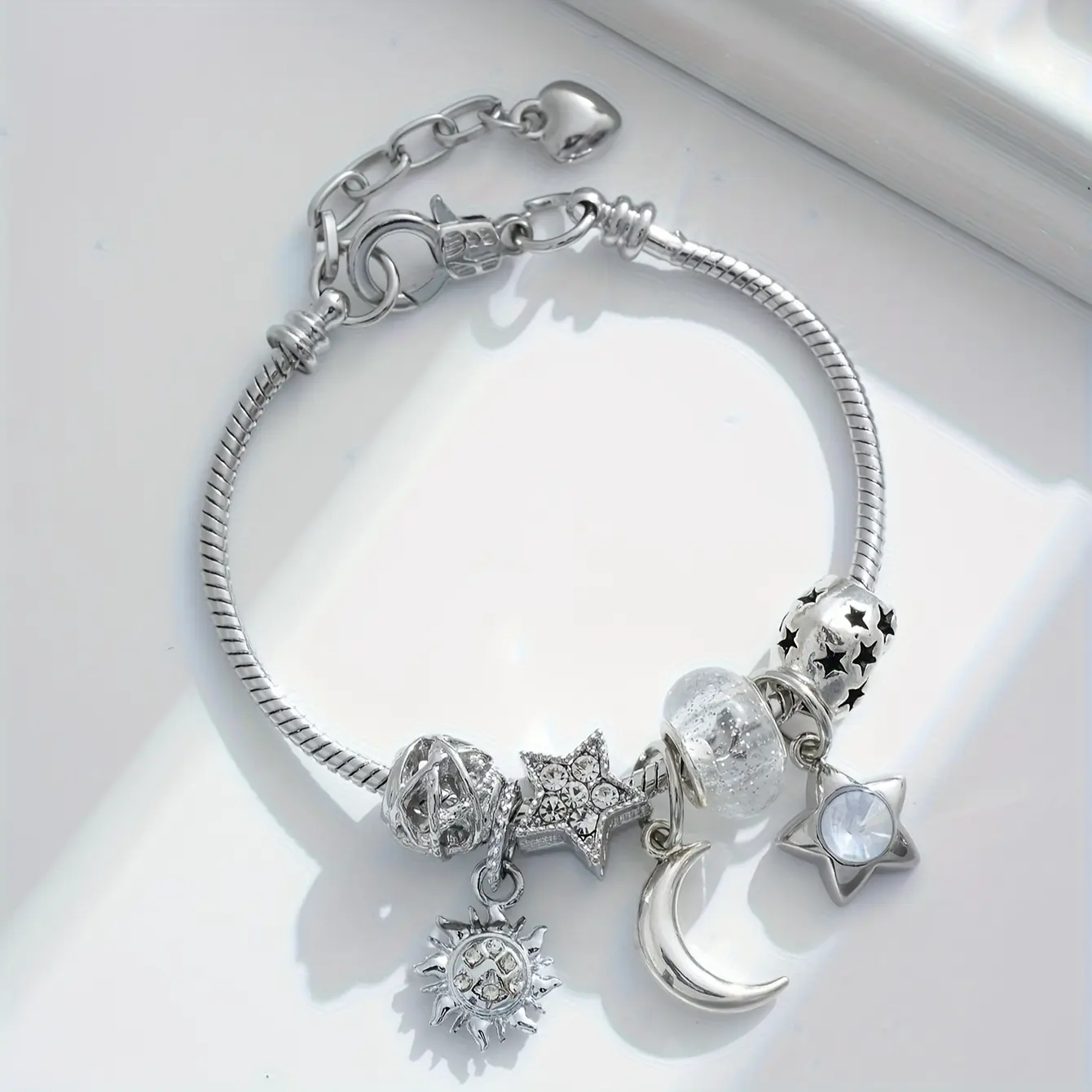A charming bracelet featuring a design of sun, moon, and stars in a pearly white moonlight hue-perfect for women; a celestial-themed gift that radiates elegance and dreams.