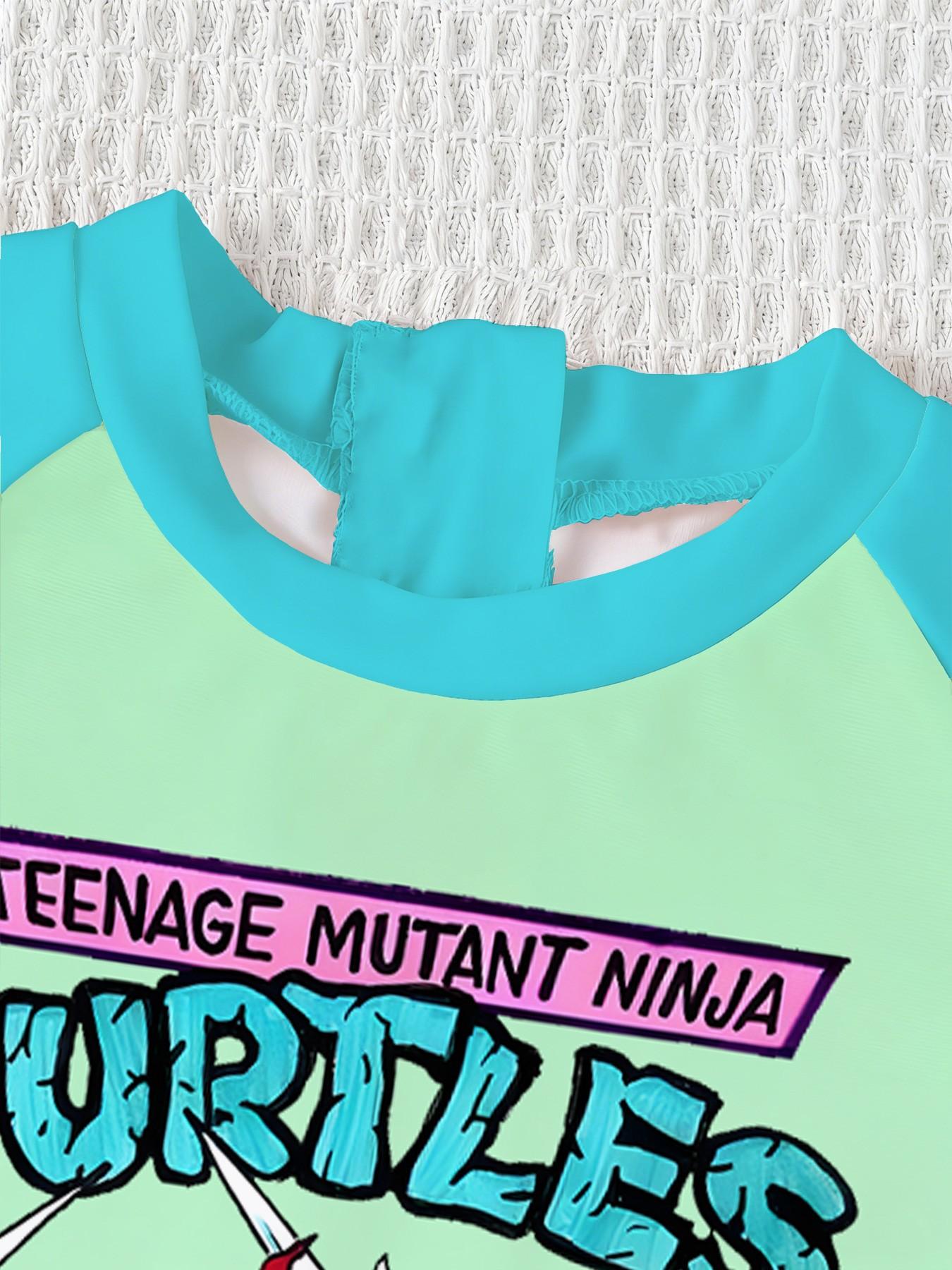 Boys' one-piece swimsuit "Ninja Turtles Breakthrough Screen Edition" features full vintage Ninja Turtles breakthrough screen print and raglan lake-blue sleeves. It is trendy, cool and sun-protective, eye-catching for summer water play and beach vacations.