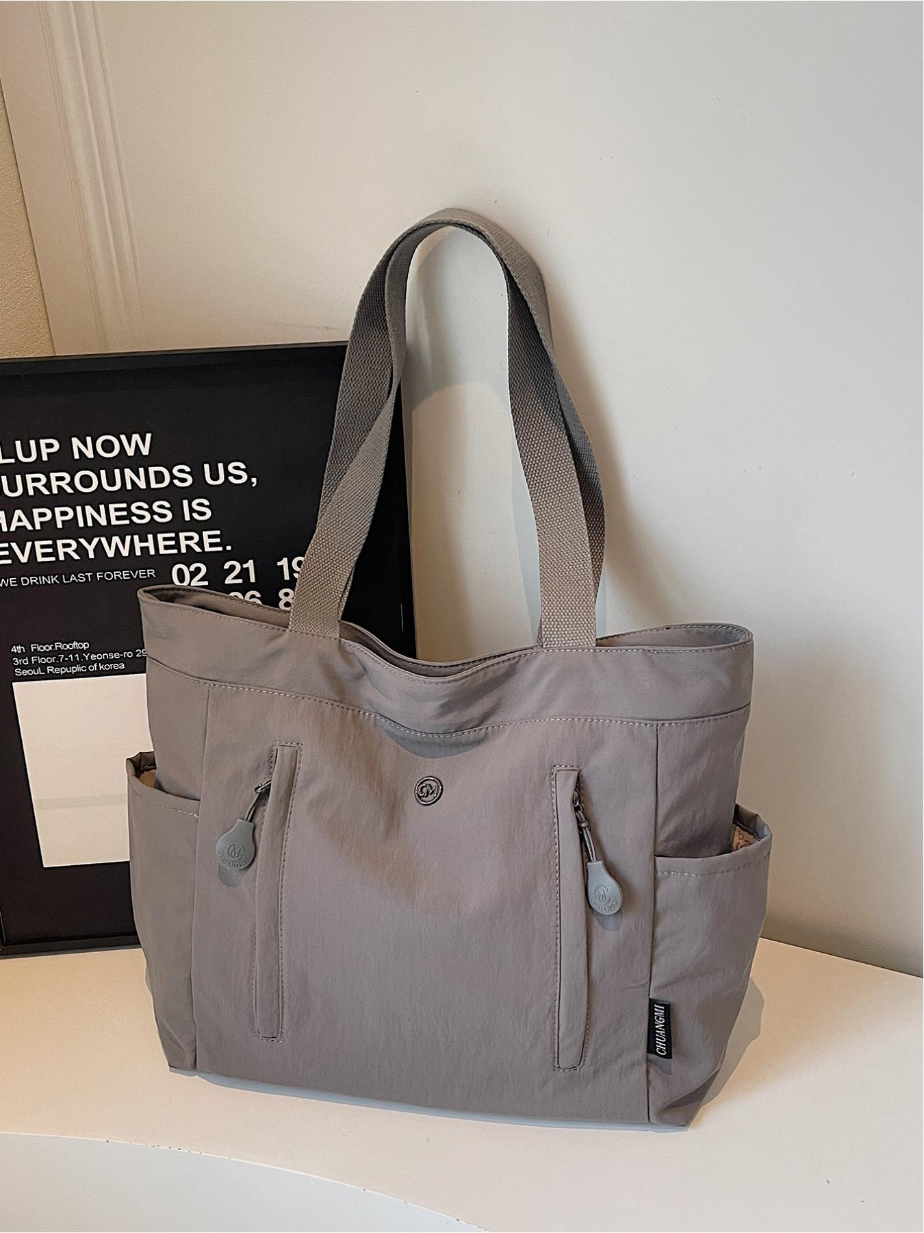 The large capacity soft commuter tote bag, is lightweight, spacious, suitable for daily use. It is a neutral waterproof nylon shoulder bag with a spacious interior suitable for 15 inch laptops, multiple side pockets, and a comfortable adjustab