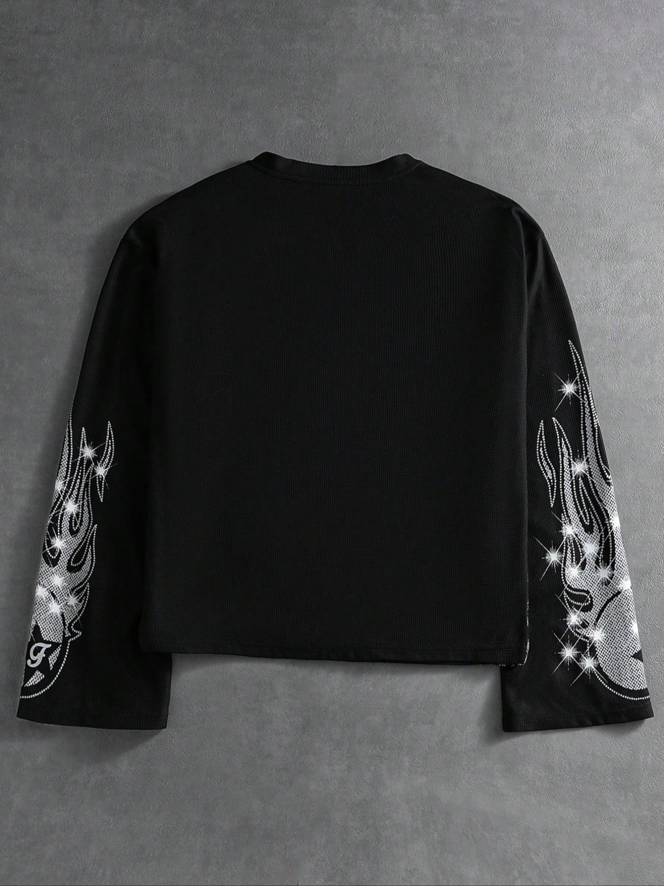 This men's two-piece set features a gothic streetwear design, including a long-sleeved T-shirt with a shimmering flame print and black flared trousers adorned with rhinestones and lettering.