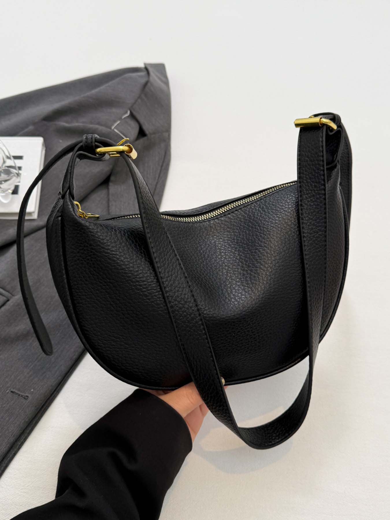 Black simple and fashionable lychee pattern crescent bag, niche pleated bag body, adjustable wide shoulder strap crossbody bag, metal buckle decoration, lightweight daily commuter bag, suitable for shopping, dating, etc.