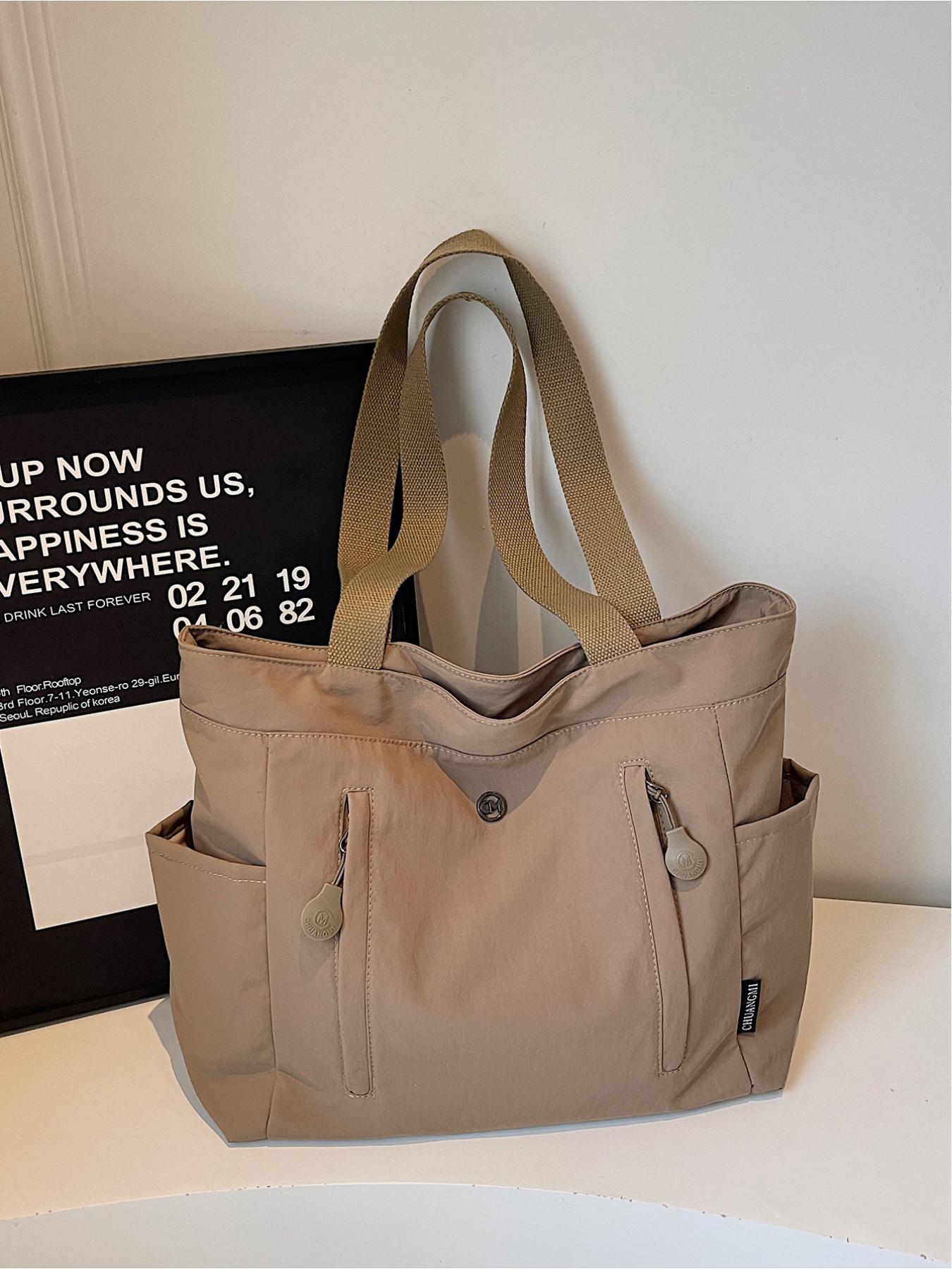 The large capacity soft commuter tote bag, is lightweight, spacious, suitable for daily use. It is a neutral waterproof nylon shoulder bag with a spacious interior suitable for 15 inch laptops, multiple side pockets, and a comfortable adjustab