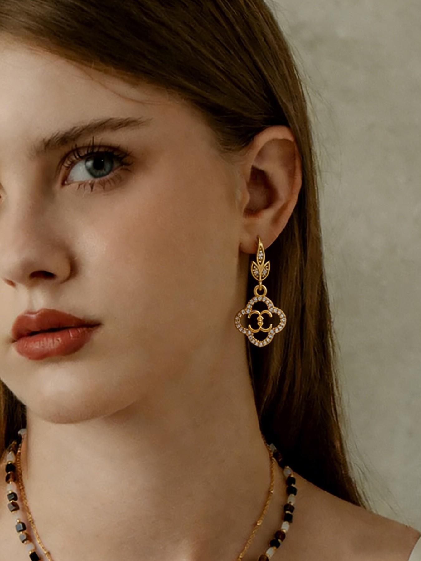 A pair of openwork flower earrings, delicate four-leaf clover earrings, and luxurious copper earrings inlaid with zircon
