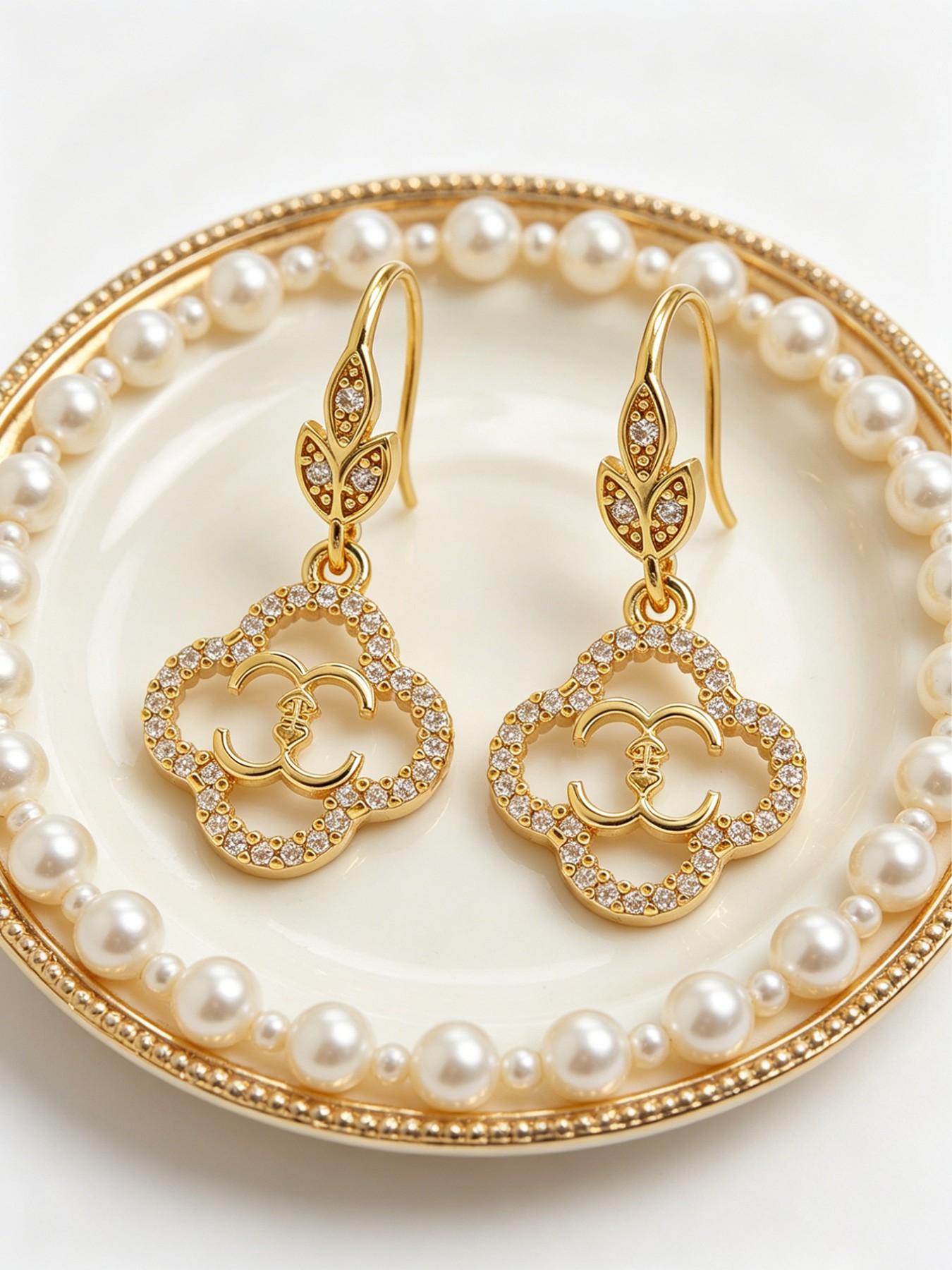 A pair of openwork flower earrings, delicate four-leaf clover earrings, and luxurious copper earrings inlaid with zircon