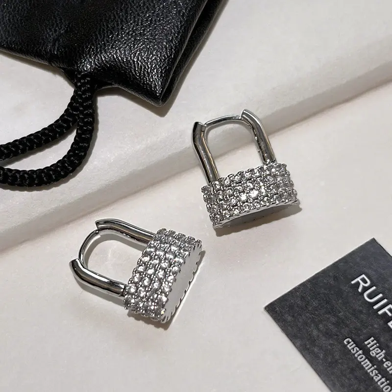 Stylish silver hoop earrings for women featuring an exquisite padlock pendant design and pavé-set crystal rhinestones; a distinctive accessory suitable for the workplace and everyday wear—an ideal gift.