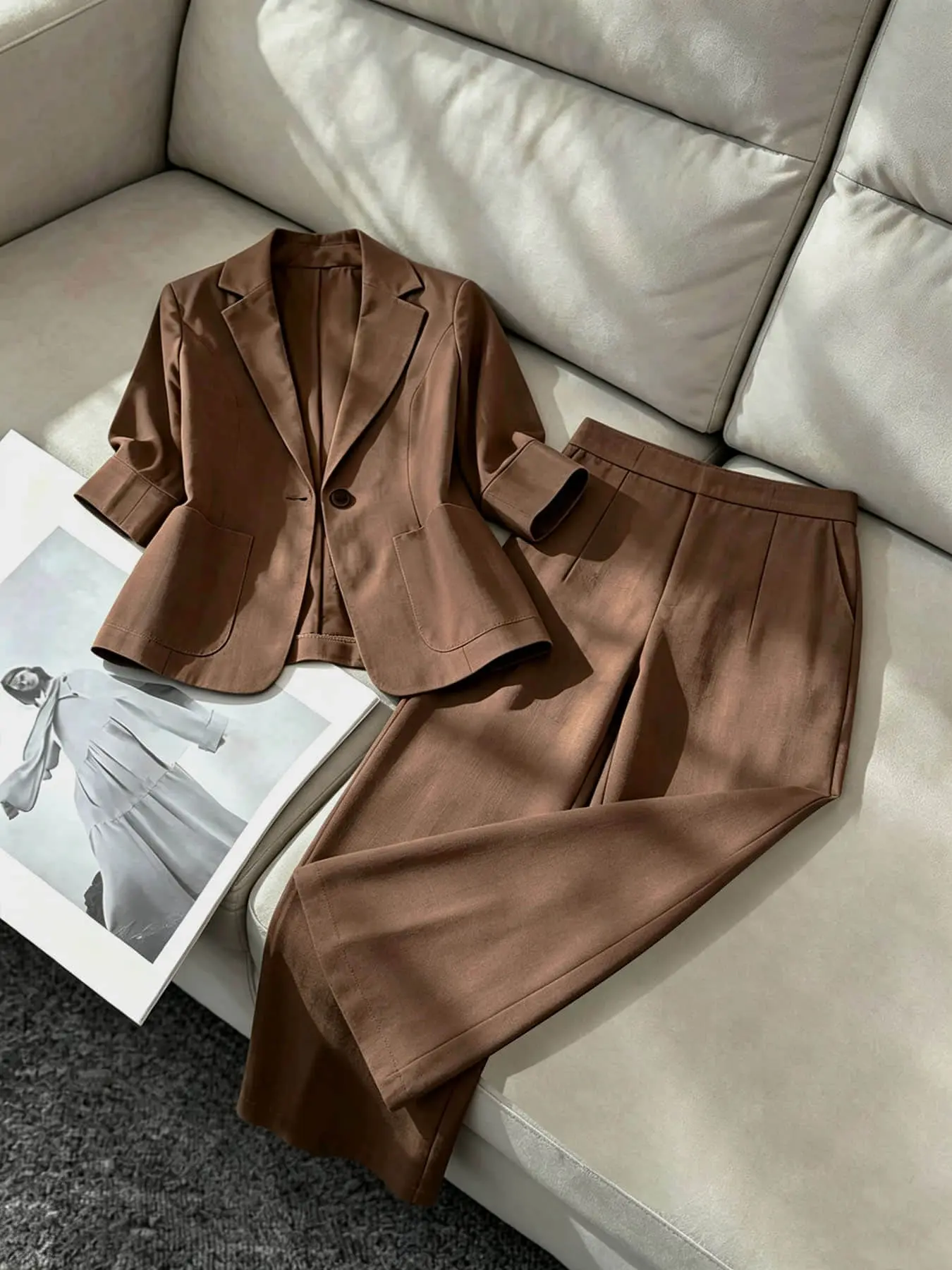 Two-piece women's fashion pantsuit set in brown, featuring a lapel, single row of buttons, curved pockets, a mid-length sleeve blazer, and high-waisted wide-leg pants. Suitable for all seasons and ideal for both business occasions and casual street wear