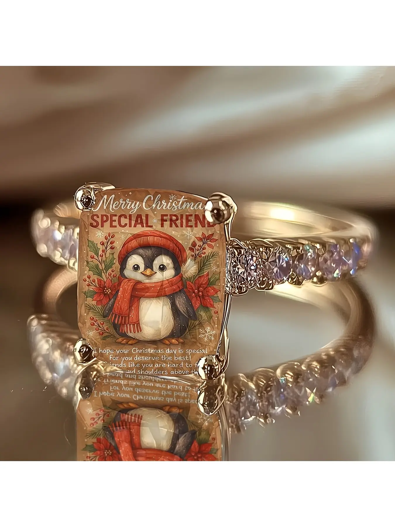 Retro paper Christmas penguin greeting ring, with a red scarf and small penguin cartoon pattern, featuring a heartfelt Christmas message for dear friends, set with diamonds on the gold band, suitable as a holiday commemorative jewelry for friends to give