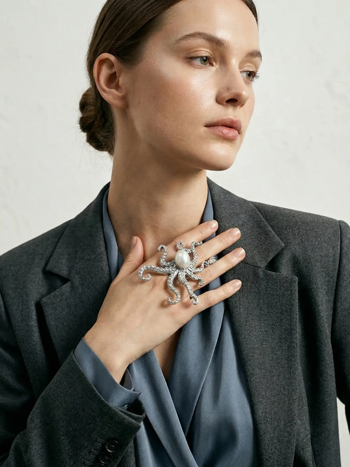 A silver octopus shaped ring featuring marine creatures, with a large central pearl paired with colored diamonds on the tentacles, suitable for wearing in dark or retro fashion, artistic events, and other settings.
