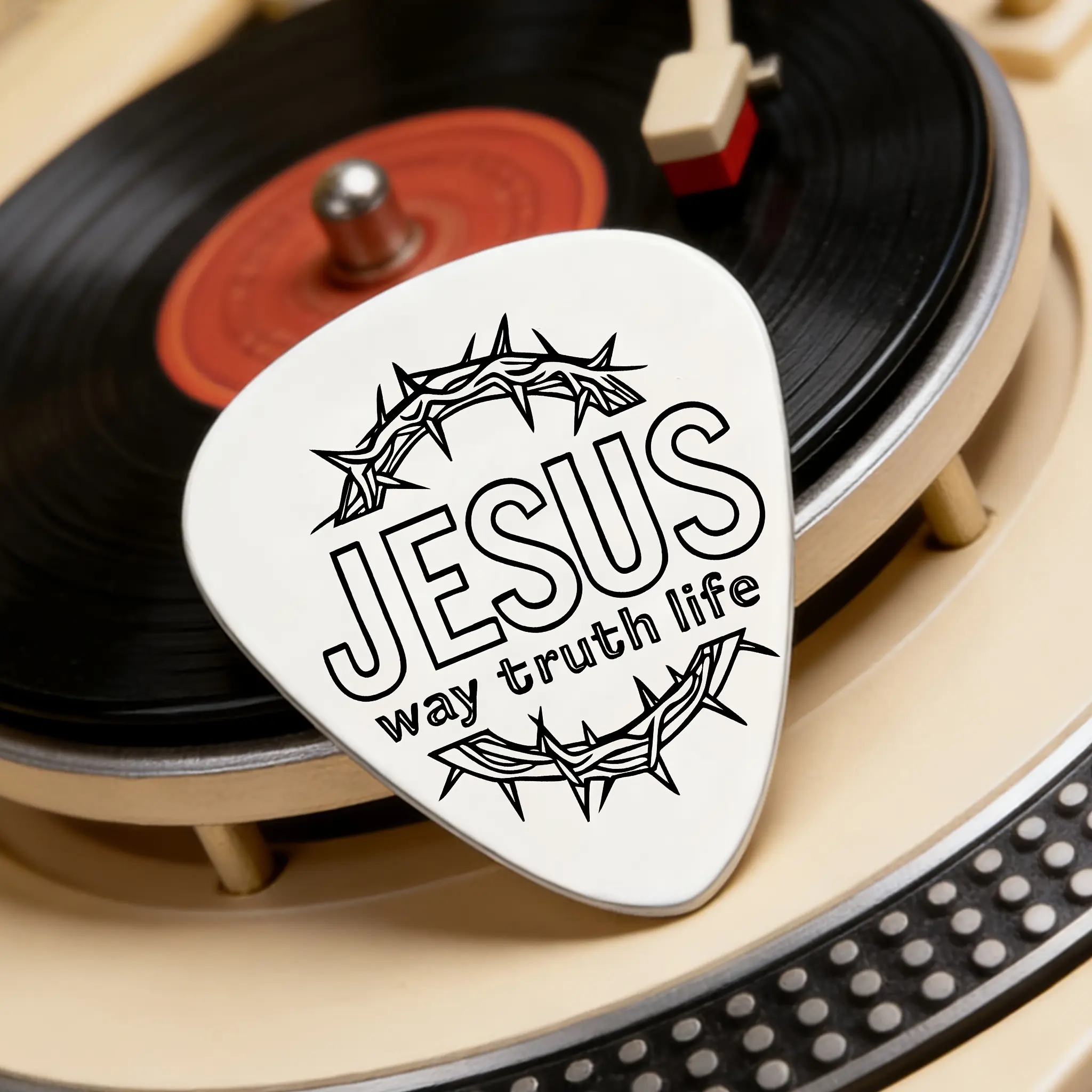 A stainless steel guitar pick engraved with "JESUS way truth life" and crown of thorns pattern design is a unique gift for relatives and friends for birthdays, holidays, and baptisms