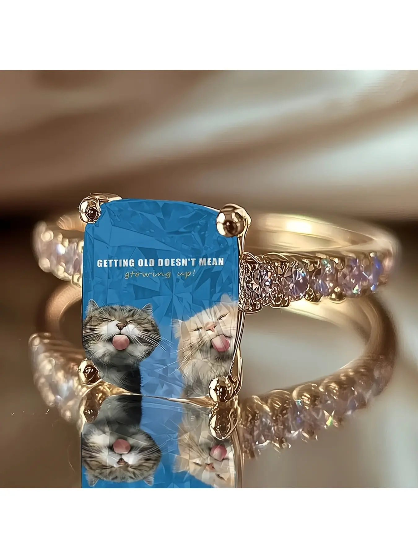 Scentless Cat Slogan Ring, with a blue background featuring cute cat patterns, set with diamonds and a golden ring band, exuding a relaxed and soothing charm, a personalized and adorable animal accessory.