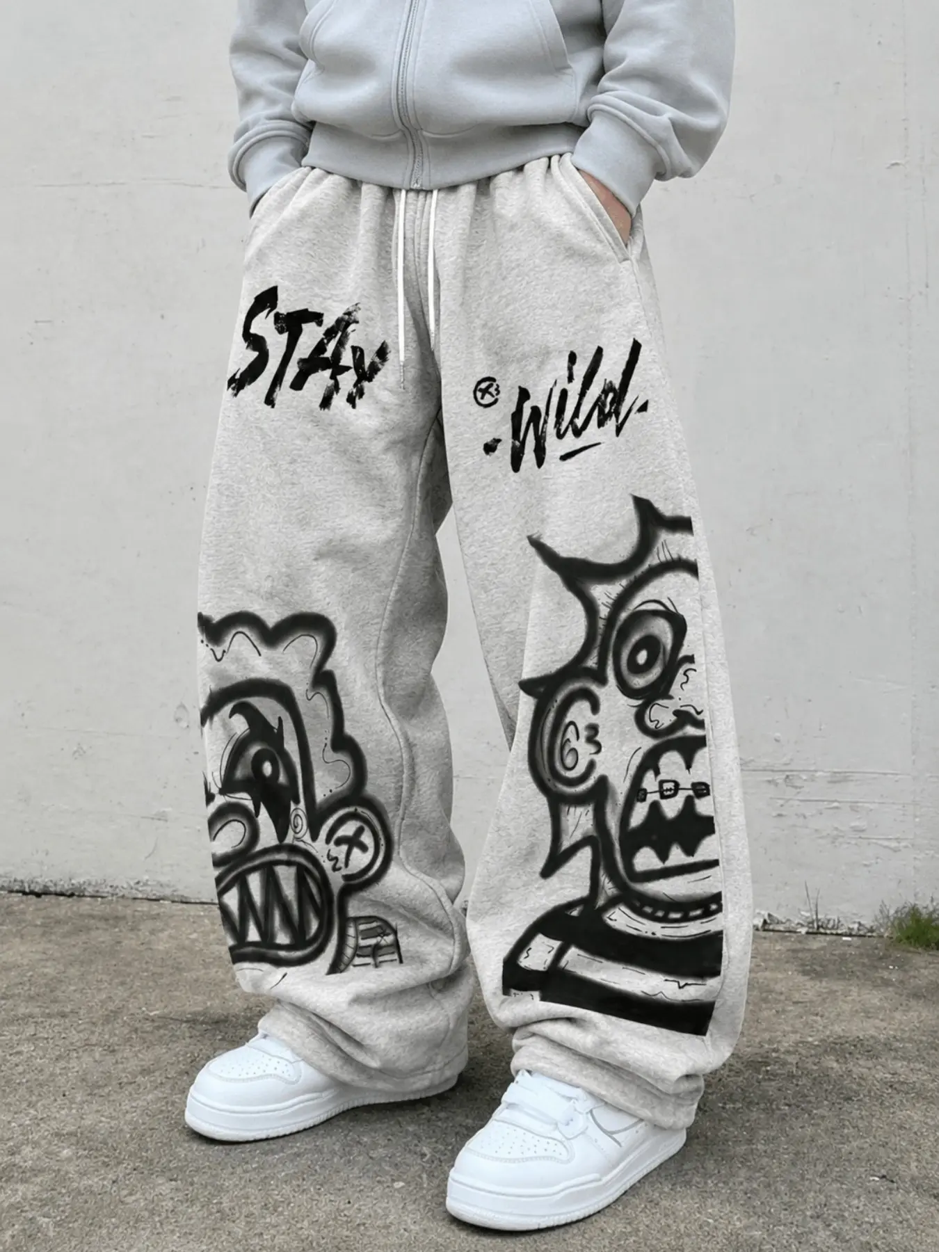 Men's Light Gray Graffiti Graphic Sweatpants, Baggy Wide-Leg Drawstring Pants with Face, Letter and STAY WILD Prints, Elastic Waist, Pockets and Relaxed Straight Legs, Y2K Streetwear for Campus, Skate, Travel, Festivals, Parties, and Casual Wear