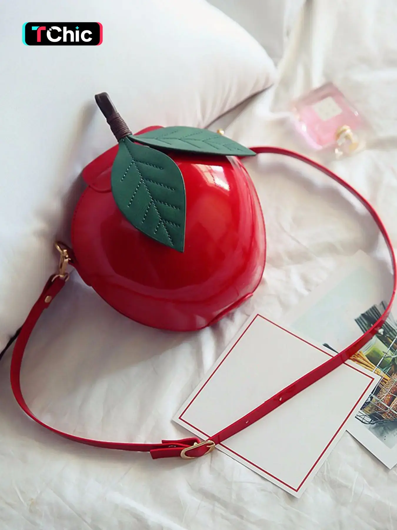 3D apple-shaped crossbody shoulder bag, accented with green leaves and a rounded structure, features an adjustable long crossbody chain for easy carrying. Stylish and versatile, perfect for daily work, commuting, shopping, or attending parties.