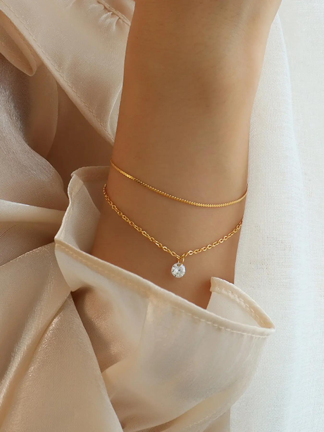 A double layered gold fine chain diamond studded bracelet, paired with a simple chain and a teardrop shaped sparkling diamond pendant, gentle and exquisite, suitable for various scenarios such as daily commuting, dating, and casual delivery.