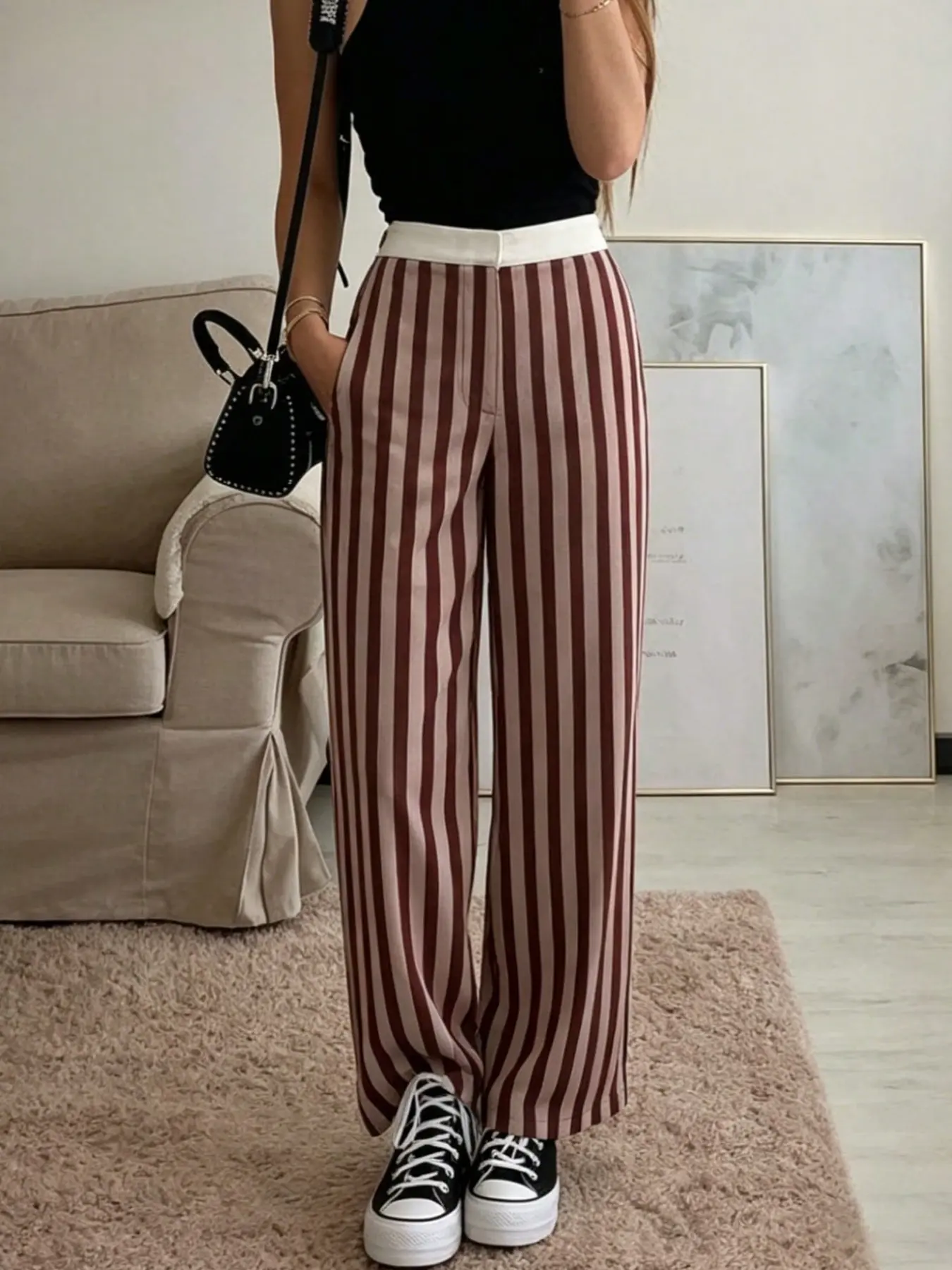 A pair of fashionable and casual vertical striped pants for women, with a contrasting white waist and hanging head, suitable for autumn and winter, suitable for home, shopping, and commuting wear