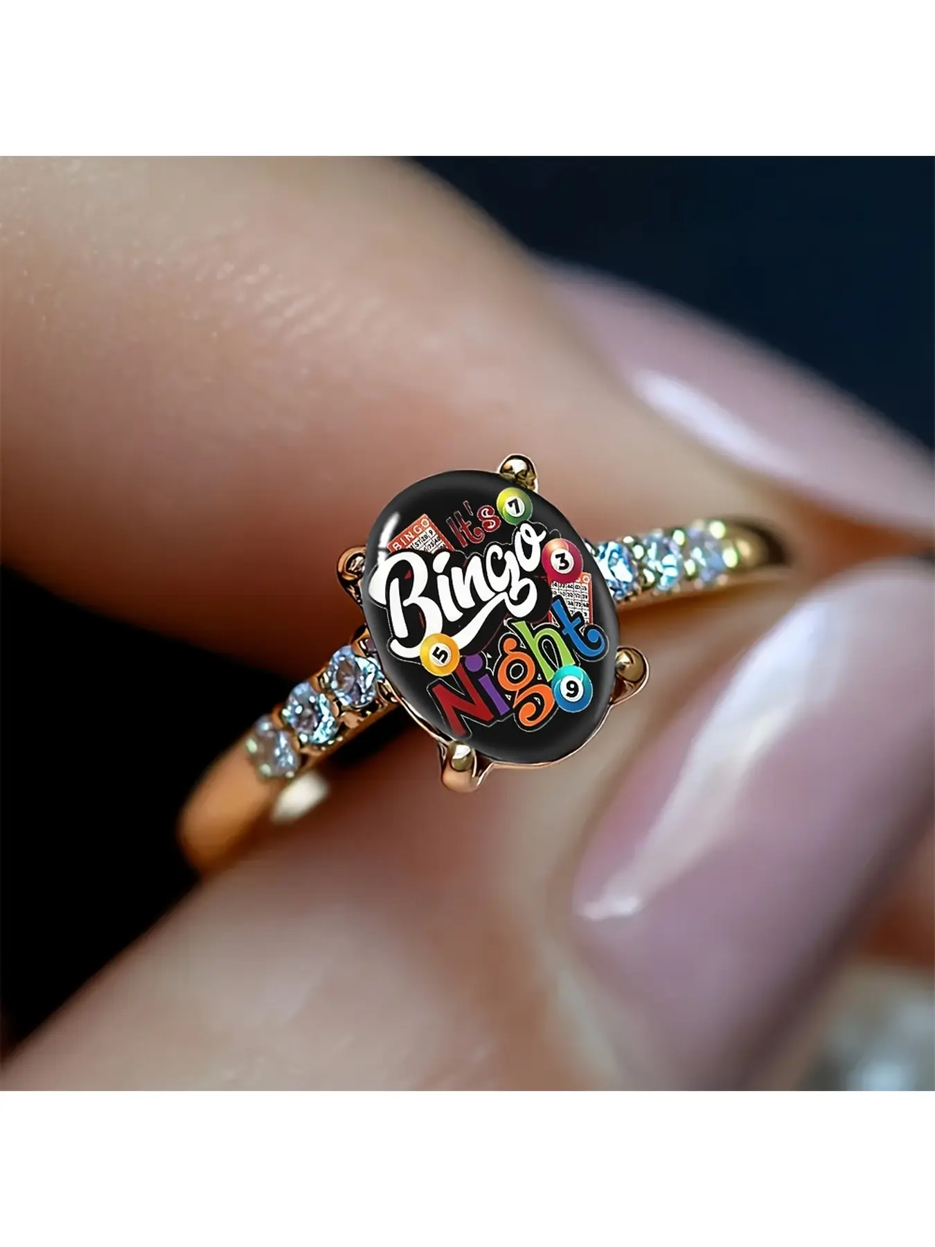 The Bingo game-themed oval rose gold ring features a black background with colorful bingo number balls and the slogan "It's Bingo Night". The vibrant colors are full of fun and appeal to Bingo game enthusiasts. It has a strong atmosphere and is a casual,