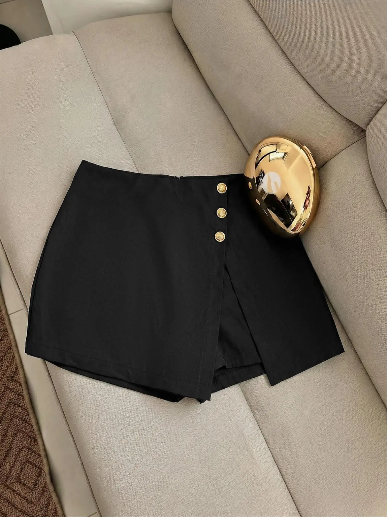 Elegant black skort for women high-waisted asymmetrical wrap design with decorative gold buttons sleek minimalist style crafted from soft breathable fabric suitable for daily trips dates vacations business occasions and office wear