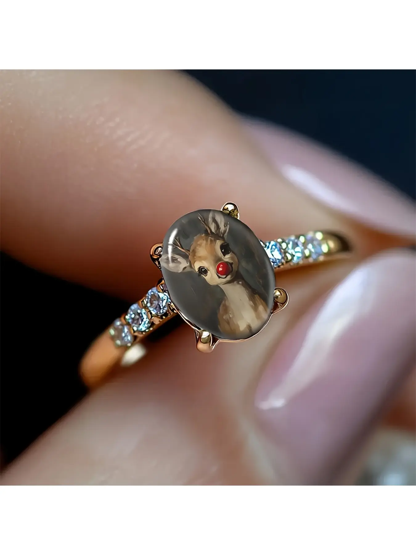 Vintage red-nosed reindeer diamond gold ring with an oil painting texture main stone depicting the classic Rudolph reindeer. A light brown deer is paired with a distinctive bright red nose. The soft and retro tones create a Christmas soothing atmosphere.