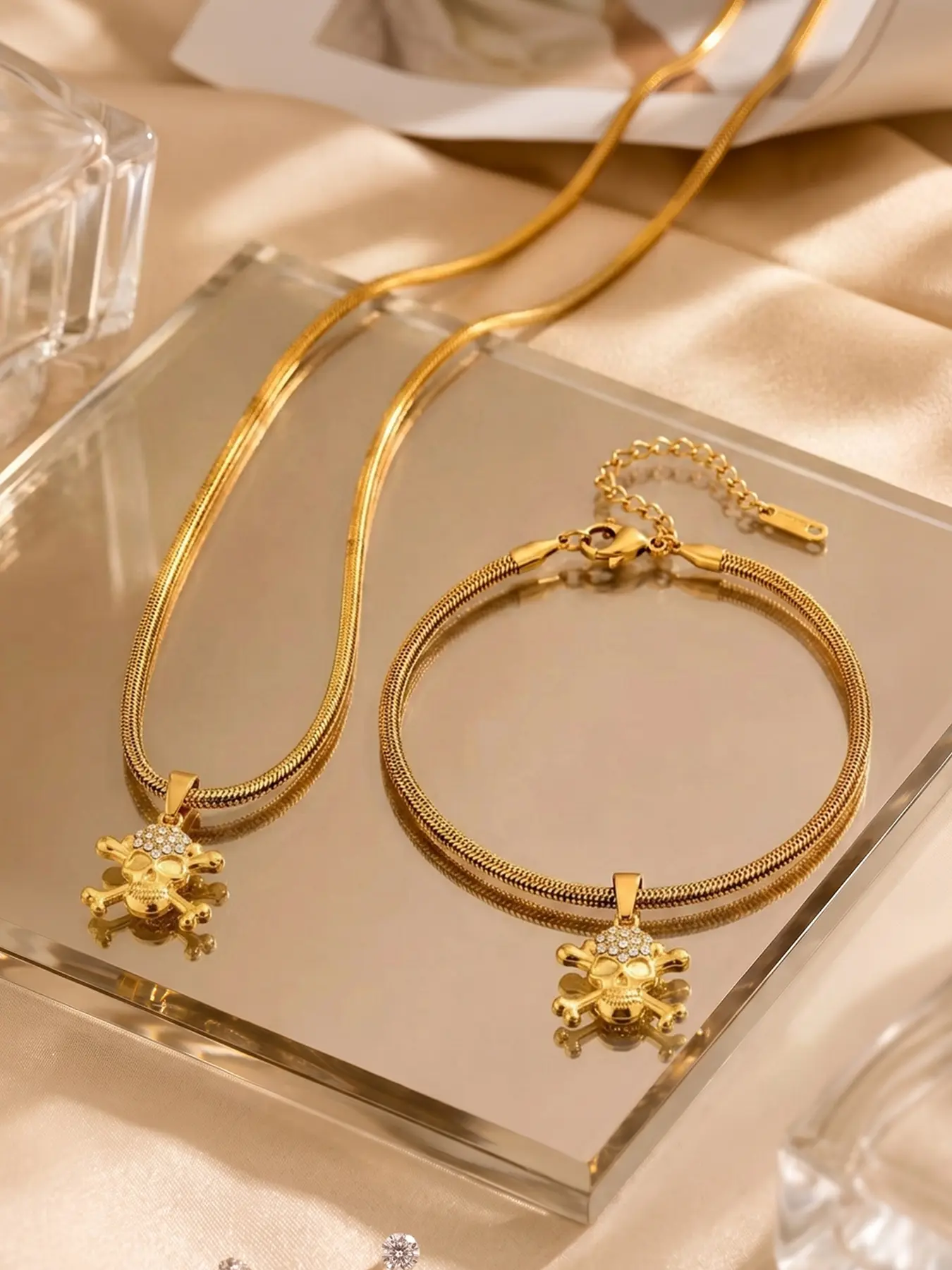 2pcs full diamond skull gold snake bone necklace bracelet set, with warm gold metal texture throughout and diamond inlaid skull cross bone design, featuring a bold personality and exquisite texture