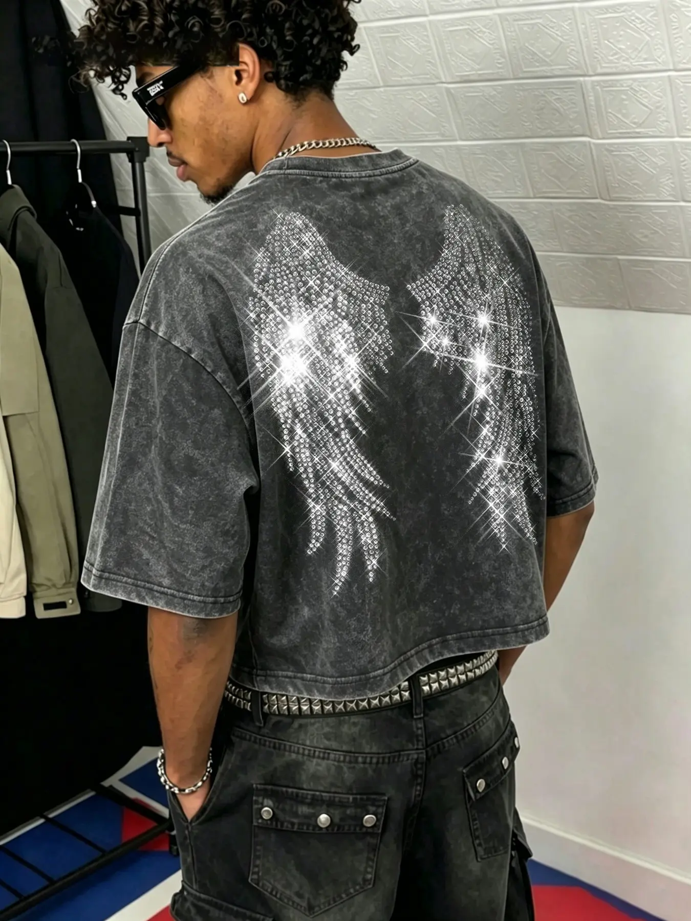 Men's washed, distressed cotton T-shirt featuring a boxy, cropped fit and a youthful, trendy crew-neck design; adorned with a rhinestone-embellished wing motif, this piece embodies a street-style aesthetic suitable for casual daily wear or commuting.