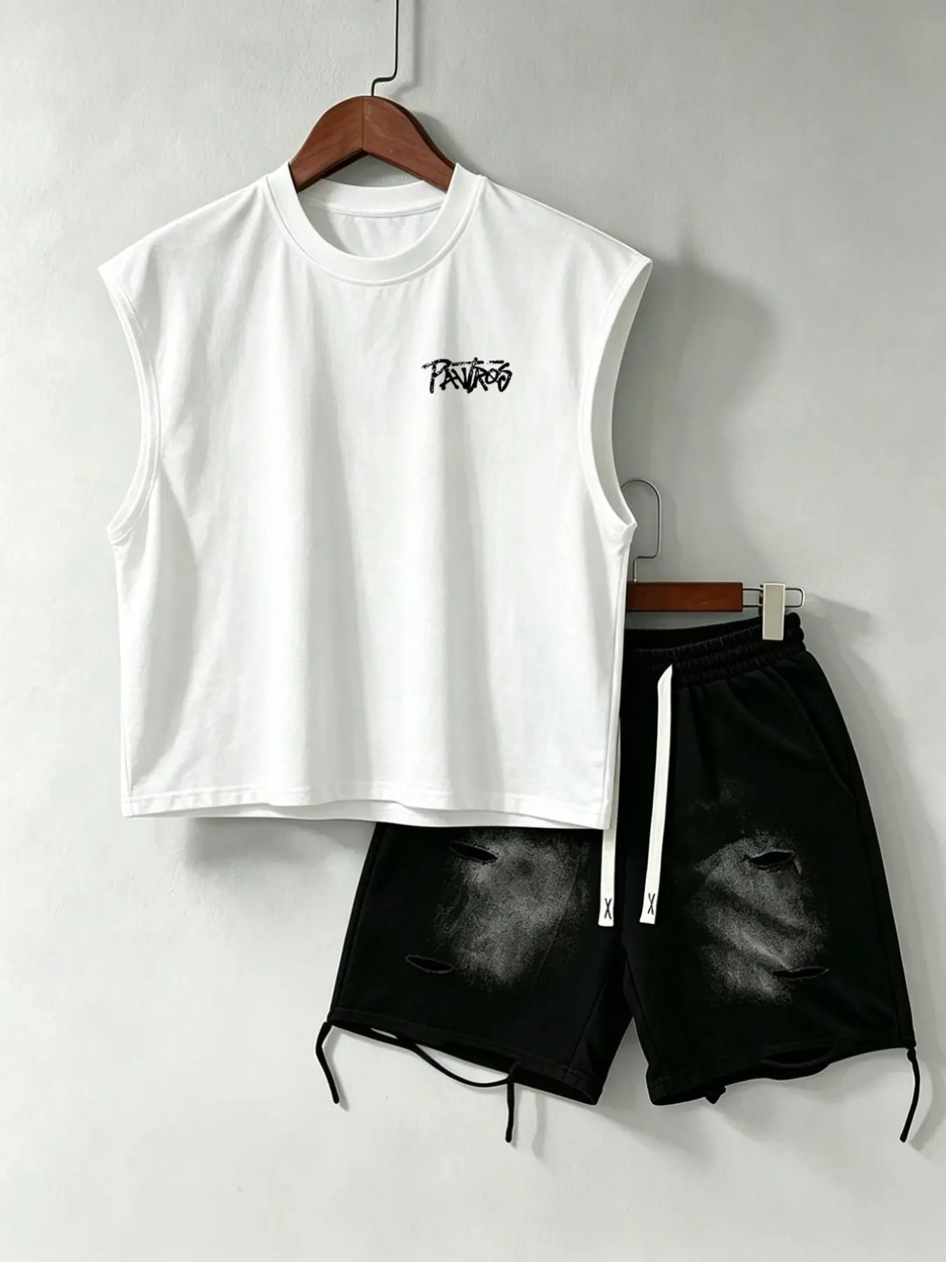 Men's sleeveless vest: A two-piece menswear set including a sleeveless vest and a pair of ripped printed shorts for a casual street style streetwear look.