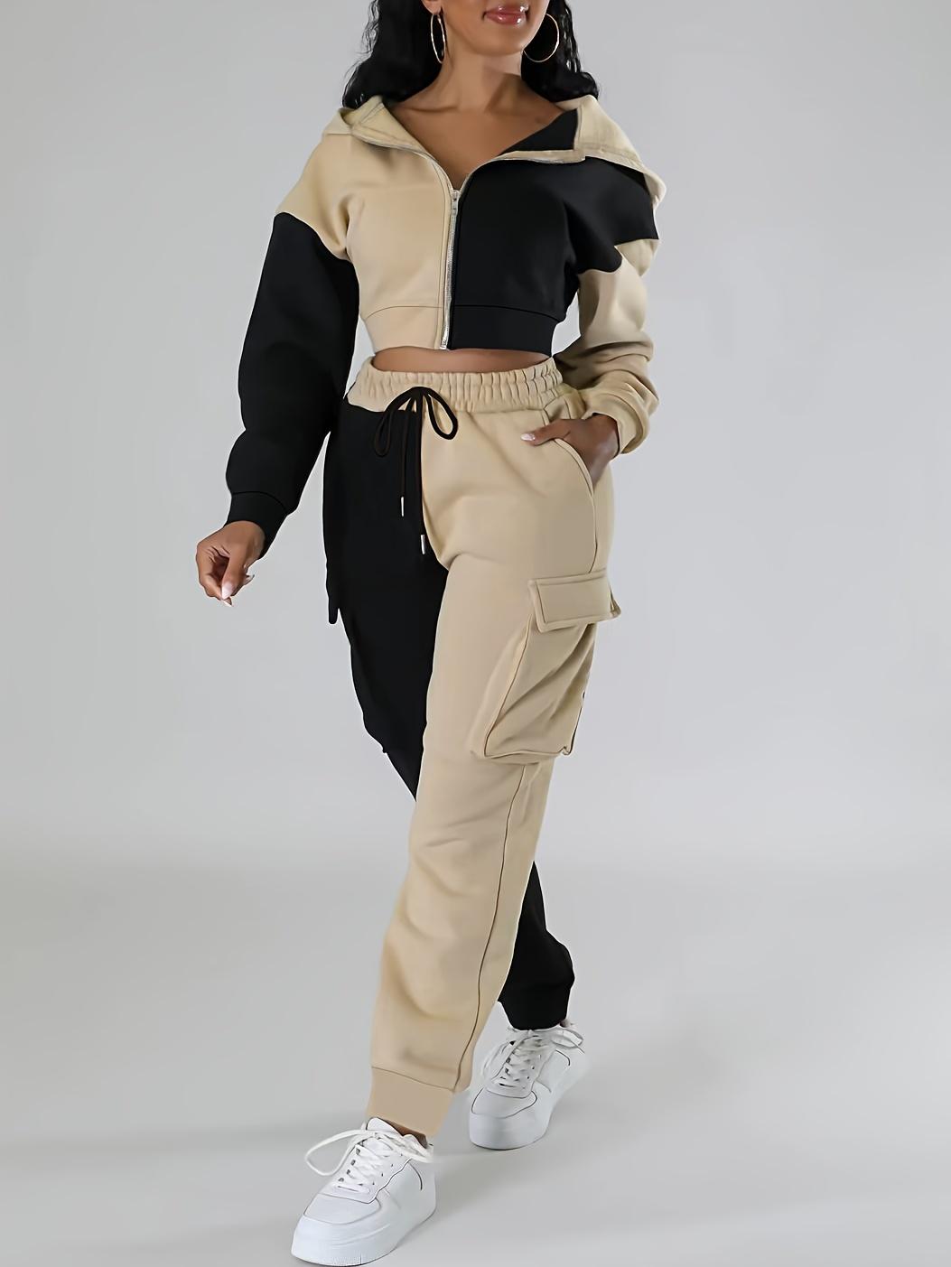 Sporty women's outfit: fashionable two-piece set with a short hooded jacket in contrasting colors and cargo sweatpants