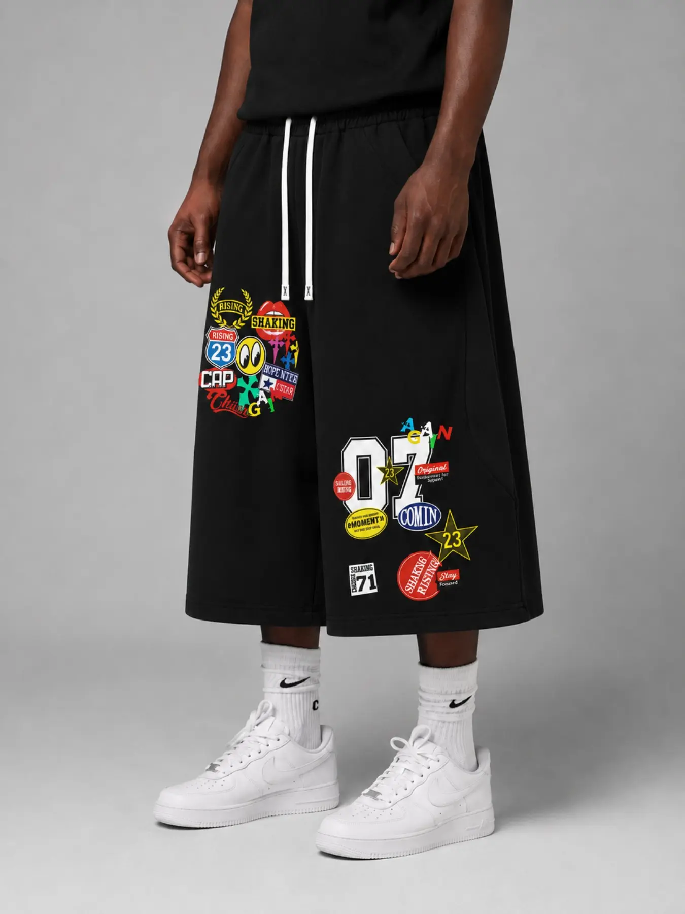 Men's Black Baggy Graphic Bermuda Shorts, Knee-Length Wide-Leg Drawstring Shorts with Colorful Cartoon Patch and Sticker Prints, Retro Y2K Graffiti Streetwear Bottoms for Summer, Campus Looks, Skate Outfits, Travel, Festivals, and Hip Hop Styling