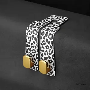 2PC Leopard-Print Car Seat Hook – Universal In-Car Organizer Hanger. Features stylish PU leather and a sturdy gold-tone metal hook design. Supports up to 10kg; suitable for hanging handbags, shopping bags, coats, and everyday items.