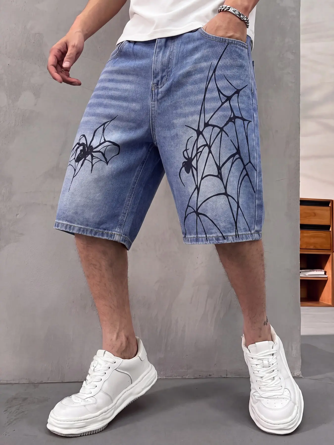 Men's streetwear denim shorts, loose baggy fit, light blue washed vintage craftsmanship, edgy spider web print y2k aesthetic vibe, summer breathable, perfect for alternative fashion outfits.