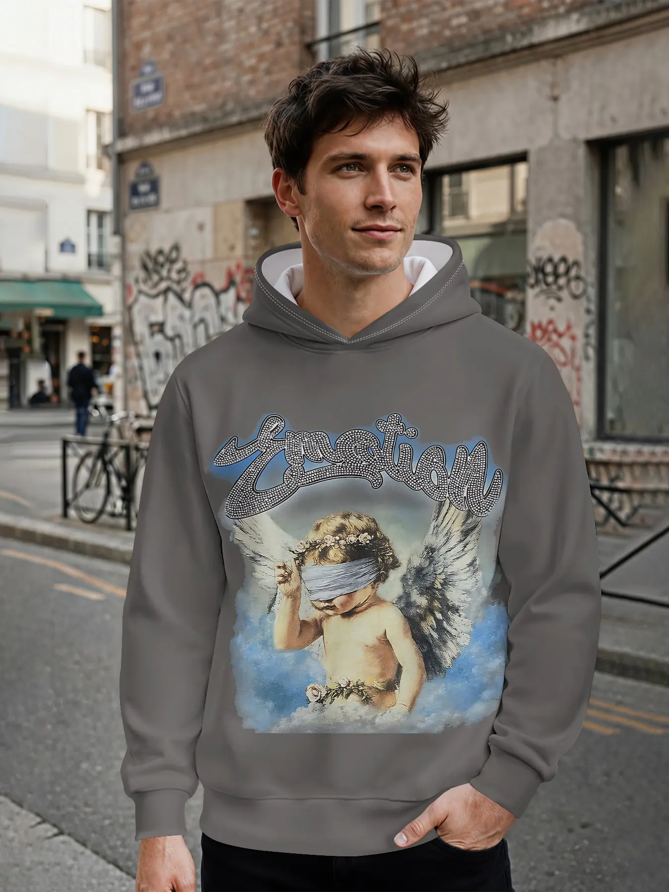 Men's hooded sweatshirt with dark grey base decorated with rhinestone cursive lettering and an oil painting print of a blindfolded angel amid clouds; a retro high-street men's hoodie. This long-sleeve casual stylish hooded jacket features 3D digital print