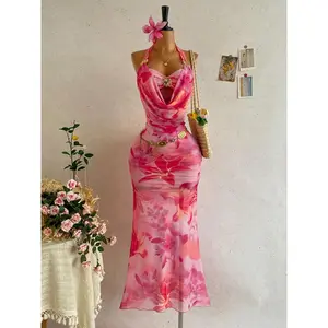 A vacation-style tie-dye floral maxi dress with a draped halter neck, featuring sheer mesh and metal buckle details. Ideal for beach getaways, tropical trips and summer parties. Women
