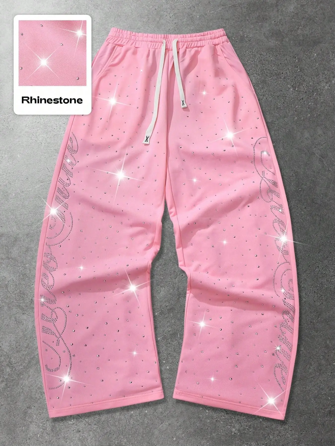 Pink rhinestone wide-leg joggers, shiny letter hot-studded loose street-style pants, elastic drawstring waist design, soft and comfortable fabric. Perfect for street photography, music festivals, parties, hanging out on campus, and weekend outings.