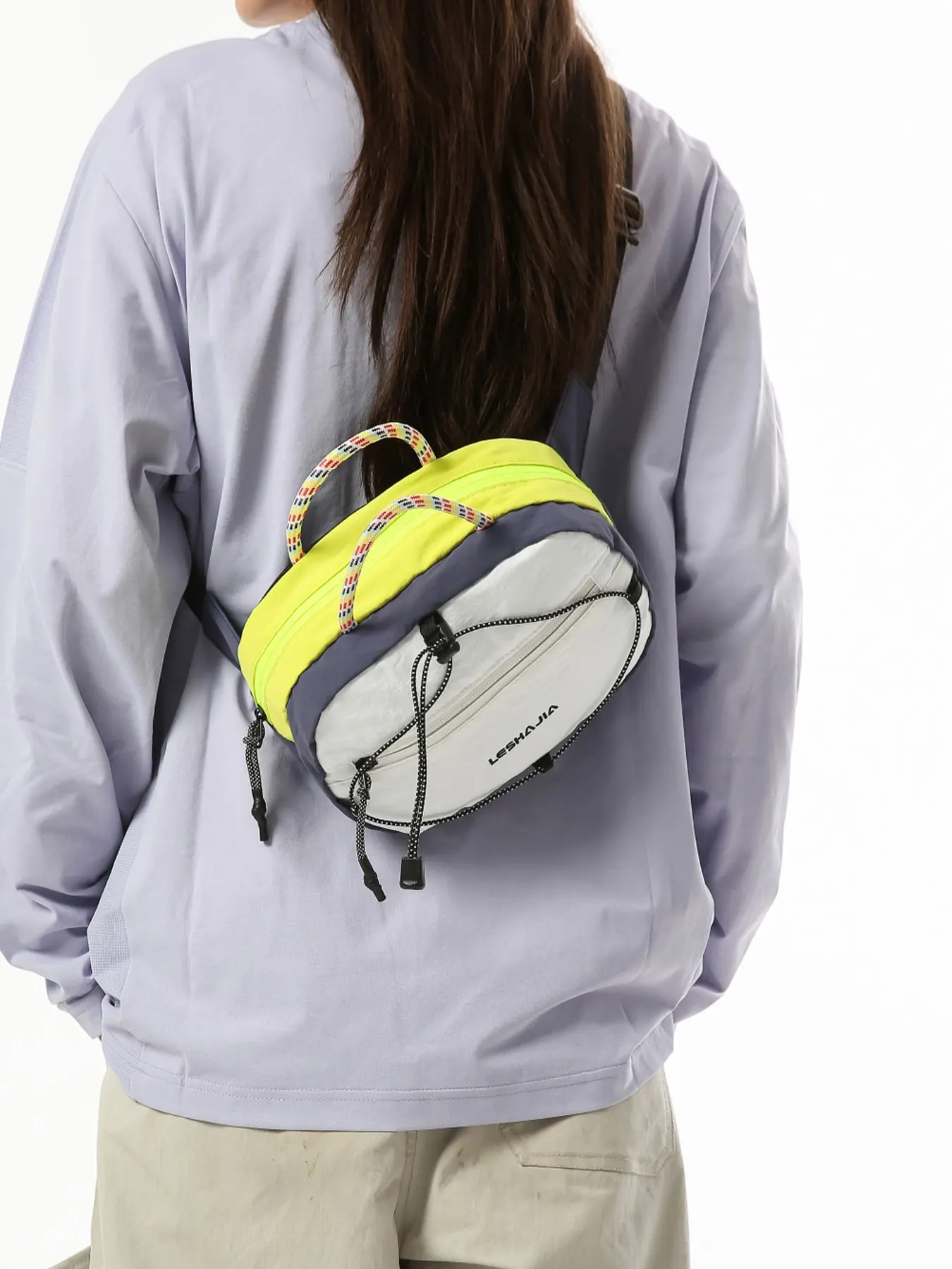 1pcOutdoor leisure crossbody bag with colorful woven hand-held rope, front pocket with drawstring design, adjustable shoulder strap, lightweight nylon chest bag, waist bag suitable for hiking, camping, daily shopping, travel and storage
