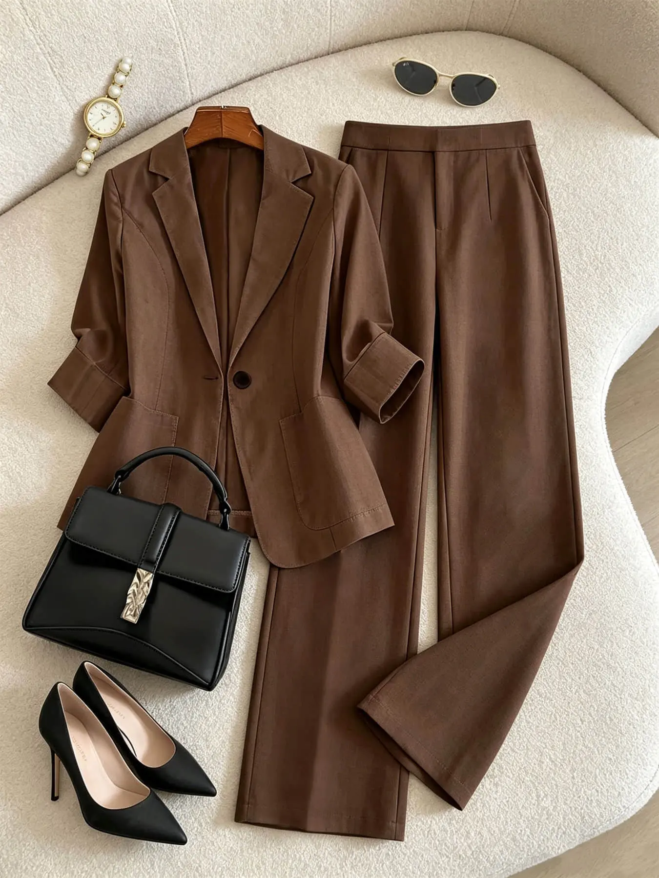 Two-piece women's fashion set in brown, Elegant featuring a lapel, single row of buttons, curved pockets, a mid-length sleeve blazer, and high-waisted wide-leg pants. Suitable for all seasons and ideal for both business occasions and casual street wear