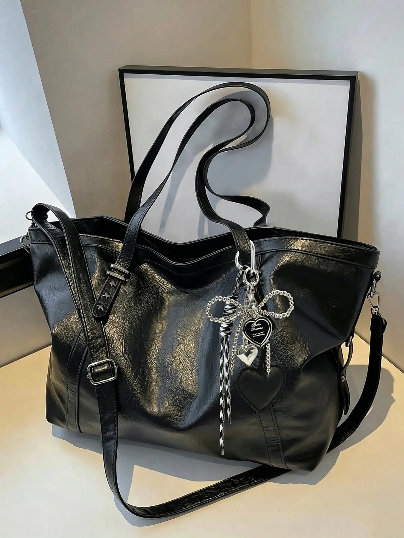 Niche design fashion vintage tote bag, featuring a personalized heart and bow chain charm decoration, with a large-capacity soft leather feel and adjustable crossbody strap, perfect for daily commutes, shopping, and travel with multiple compartments.