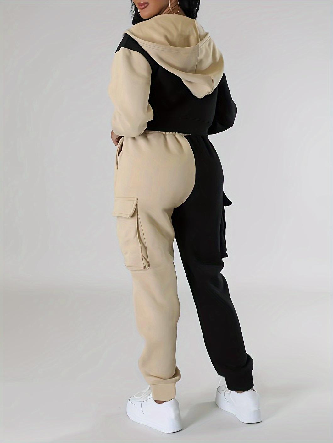 Sporty women's outfit: fashionable two-piece set with a short hooded jacket in contrasting colors and cargo sweatpants