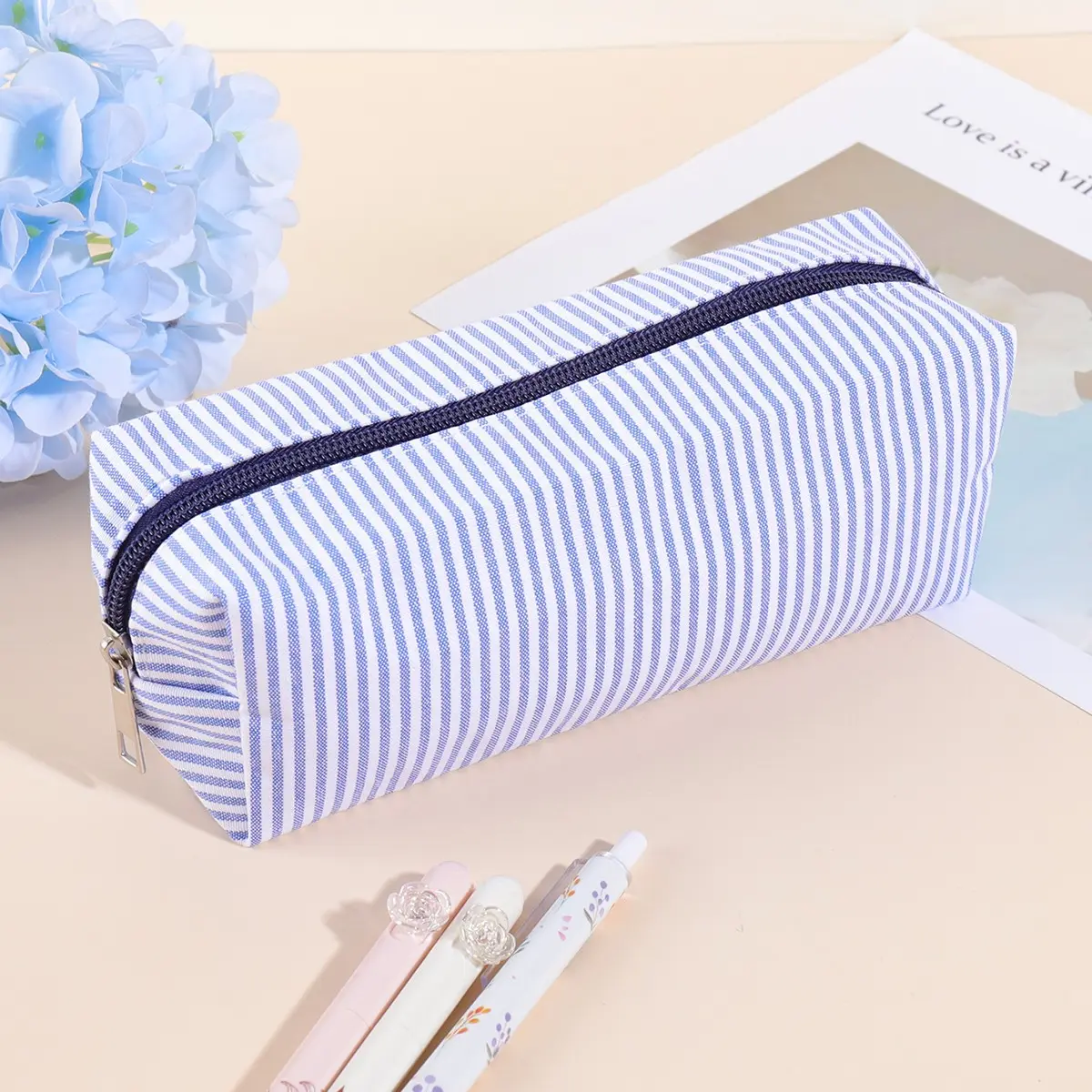 A simple striped pencil case with a smooth zipper and spacious storage. It can hold pens, pencils, markers, and small accessories. A basic stationery bag, perfect for school, office, college, travel, art class, and everyday desk organization.