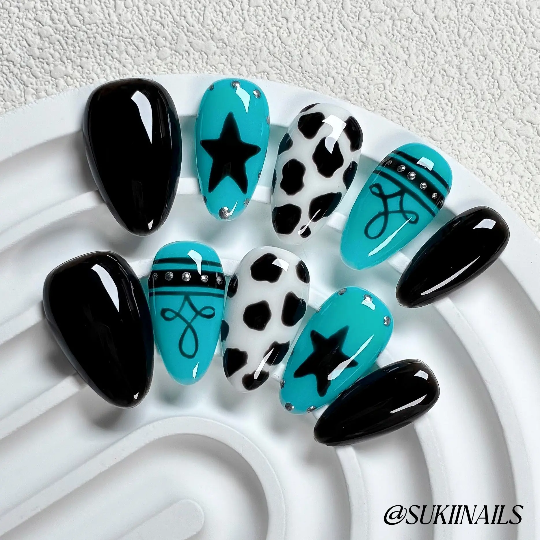 Y2K Cow Print Star Press On Nail Set | Short Almond, 10pcs Handmade glossy nails with turquoise & black color block, cow spots, star & line art with tiny rhinestones, edgy reusable fake nails for street shots, live shows & alt markets