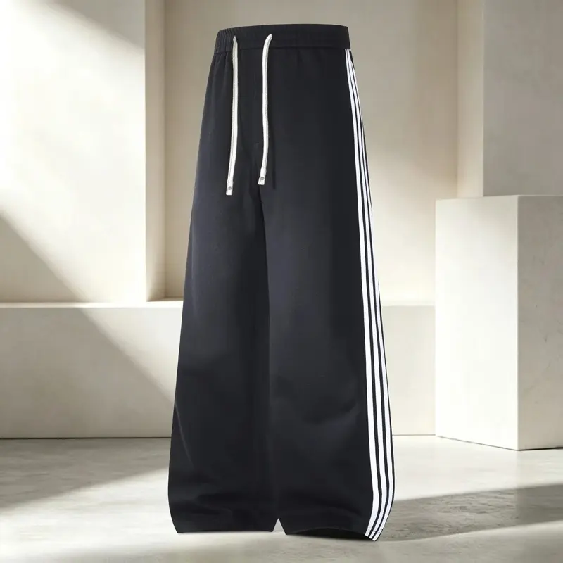 Elastic drawstring waist wide leg track sweatpants, three vertical white stripe details on side seams, oose floor-length baggy silhouette, classic sporty casual style for daily commutes, jogging and street layered matching outfits