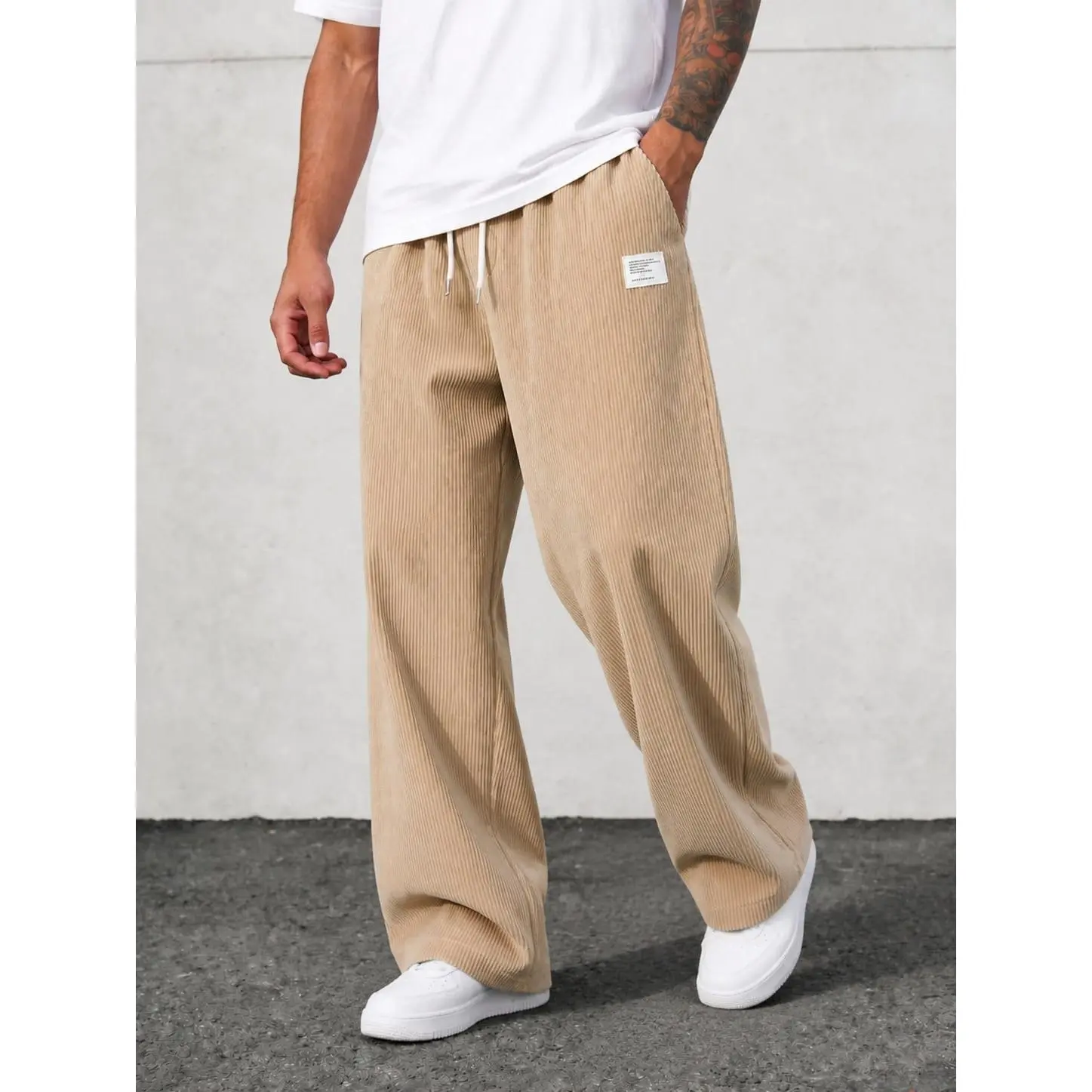 Vintage corduroy wide leg casual trousers with elastic drawstring waist, vertical ribbed textured fabric loose floor-length silhouette small label detail retro relaxed bottom staple for street modern mensfashion styling