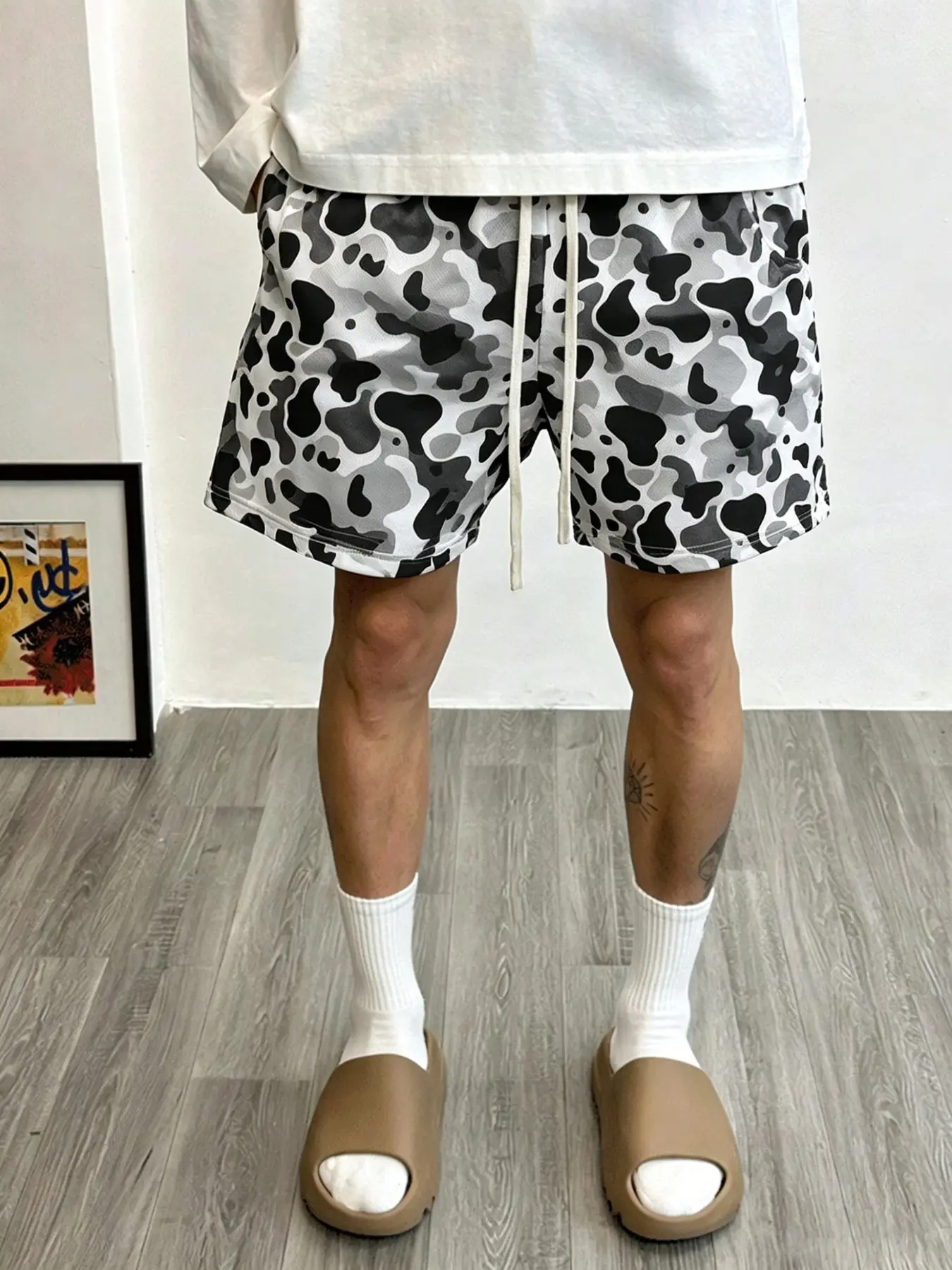 Casual shorts featuring an accommodating elastic waistband and a lightweight, breathable mesh fabric; suitable for vacations, lounging at home, or everyday wear; available in a three-color camouflage pattern.
