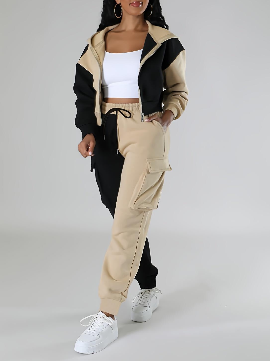 Sporty women's outfit: fashionable two-piece set with a short hooded jacket in contrasting colors and cargo sweatpants