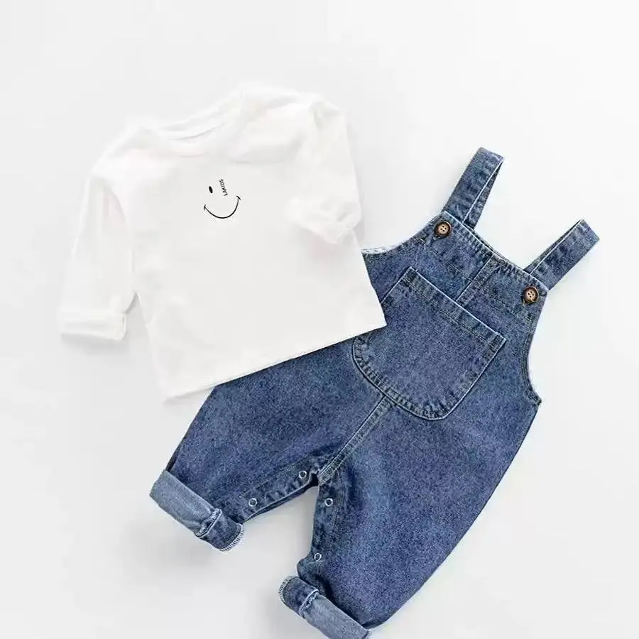 Boys' denim overalls set, classic blue denim overalls paired with a white T-shirt, simple and stylish. The overalls feature metal button design, adding a vintage touch. The pockets are practical and attractive, and the pant legs have a cuffed design
